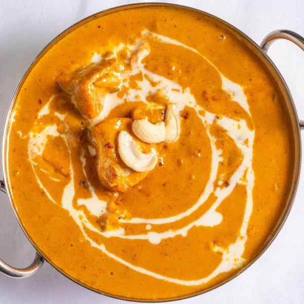 Raag Indian Cuisine's creamy chicken curry, garnished with cashews and a swirl of cream.