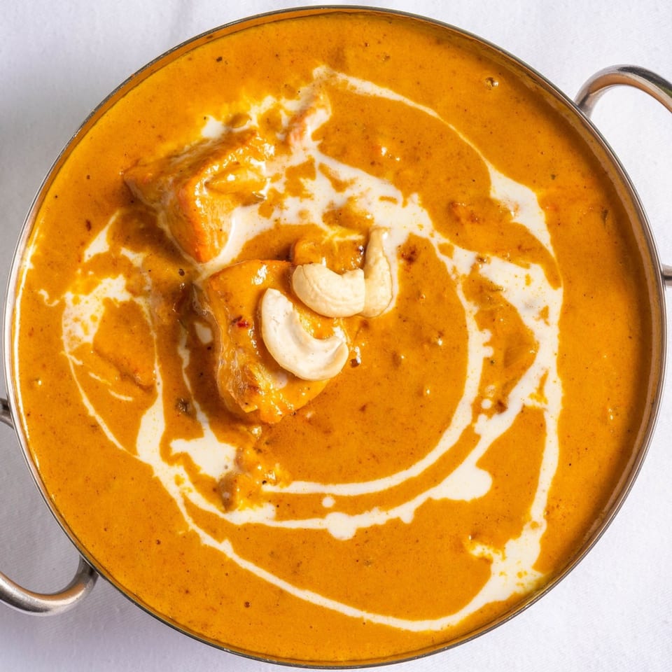 Raag Indian Cuisine's creamy chicken curry, garnished with cashews and a swirl of cream.